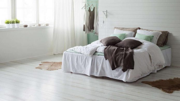 Спальня с белым лапинатом на полу и стенах