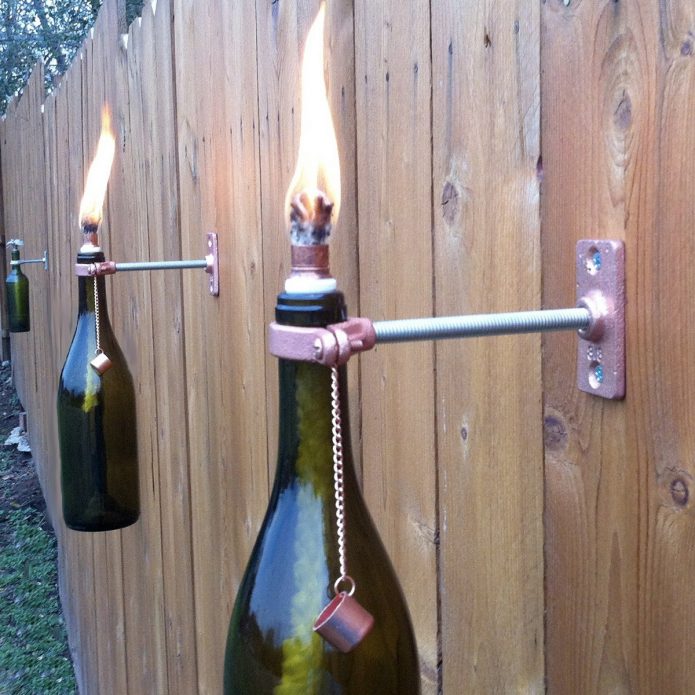 Масленые лампы из бутылок на дачном заборе